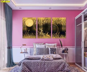 ชุดภาพติดผนังสามแผงลายกวางในป่ากลางคืน แสงพระจันทร์สีทองส่องประกายเหนือทุ่งหญ้าบนผนังห้องนอนโทนชมพูขาว เตียงลายจุดและผ้าม่านเทา สื่ออารมณ์อบอุ่นหรูหรา เหมาะงานแต่งห้องสไตล์ร่วมสมัย