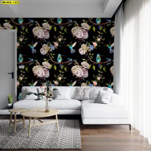 ผนังลายดอกกุหลาบครีมและนกฮัมมิงเบิร์ดสีฟ้าเขียว บนพื้นดำ ในห้องนั่งเล่นโซฟาแอลสีขาว พื้นไม้ พรมลายเรขาคณิต และผ้าม่านกรองแสง สร้างบรรยากาศโรแมนติกคมชัด