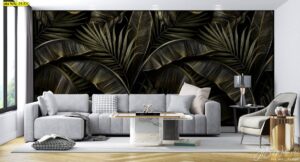 วอลเปเปอร์ดาร์กโบทานิคใบปาล์มและกล้วยซ้อนชั้นบนพื้นดำ จัดในห้องนั่งเล่นโซฟาผ้าเทาสว่าง โต๊ะกลางหินอ่อน โคมไฟโต๊ะสีเข้ม และหน้าต่างแสงธรรมชาติให้มิติหรูนิ่ง