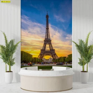 ผนังภาพหอไอเฟลสูงตระหง่านกลางสวน โทนฟ้าส้มยามเย็น รายล้อมด้วยกระถางใบเขียว จัดคู่เคาน์เตอร์รับแขกทรงวงกลมสีอ่อน ช่วยสื่อความทันสมัยและอบอุ่นของพื้นที่ต้อนรับ