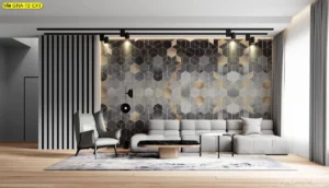 การตกแต่งผนังโรงแรมสไตล์โมเดิร์นด้วย วอลเปเปอร์ลายกราฟิกหกเหลี่ยม สีเทา-ทองในมุมนั่งเล่น สร้างบรรยากาศอบอุ่นและทันสมัยน่าพักผ่อน