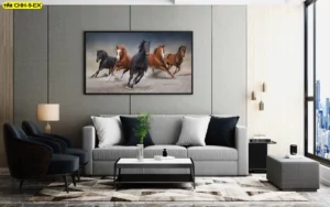 ห้องรับแขกสไตล์ลอฟท์ทันสมัยตกแต่งกรอบรูปวอลเปเปอร์ลายม้ามงคล 5 ตัววิ่งบนพื้นทรายสื่อถึงการรวมพลังสามัคคีสู่จุดหมาย