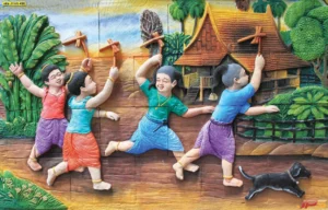 ภาพลายไทยนูนต่ำ 3 มิติ การละเล่นขี่ม้าก้านกล้วยของเด็กไทยในอดีตหน้าบ้านทรงไทยที่ดูสดใสและย้อนวัยเด็กได้ดี
