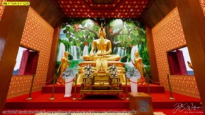 ภาพมุมหน้าตรงของห้องพระโทนแดงทอง มีฉากธรรมชาติสีเขียวด้านหลัง ช่วยให้เห็นภาพรวมการจัดวางผนังและองค์ประธาน